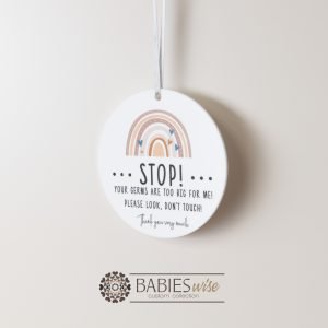 Round white acrylic plaque with hole for hanging on a pram or cot , UV printed with "STOP!" with message and a rainbow illusration. Styled hanging by a ribbon.
