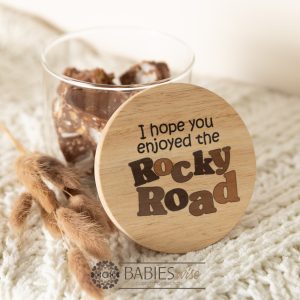 Glass gift jar with timber lid featuring UV printed quote " I hope yoy enjoyed the rocky road" styled with treats inside the jar on a soft blanket.