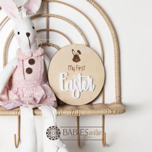 Round timber " My First Easter" plaque with engraved bunny face and 3D acrylic "Easter" lettering. Styled with a soft blanket and woven pillow.