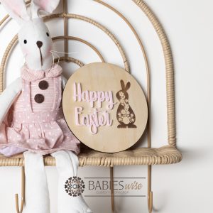 Happy Easter round timber plaque with laser engraved floral bunny and 3D acrylic "Happy Easter" lettering. Styled with a soft toy bunny on a wicker chair.