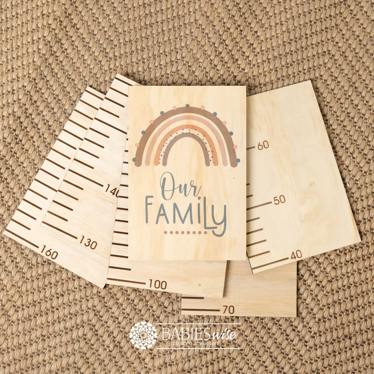 Timber growth chart with five panels and a header with a earthy rainbow with "Our Family" text. Styled with a woven mat.