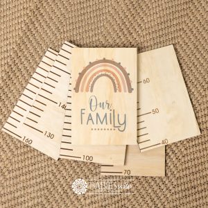 Timber growth chart with five panels and a header with a earthy rainbow with "Our Family" text. Styled with a woven mat.