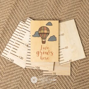 Timber growth chart with five panels and UV printed header hot air balloon with "Love grows here" text. Styled with a woven mat.