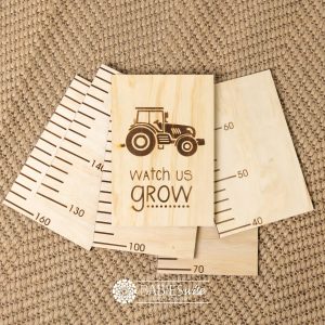 Timber growth chart with five panels and laser engraved header with tractor with "Watch Us Grow" text. Styled with a woven mat.