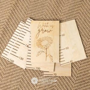 Timber growth chart with five panels and laser engraved header with "Watch Us Grow" text with a sunflower. Styled with a woven mat.