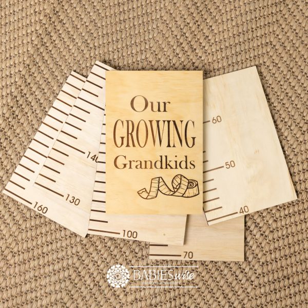 Timber growth chart with five panels and laser engraved header with "Our Growing Grandkids" text with a tape measure design . Styled with a woven mat.