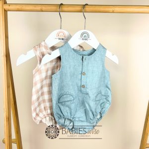 White personlised children's hanger with brown- tone rainbow and custom name. Styles on a hanger with baby's clothes.