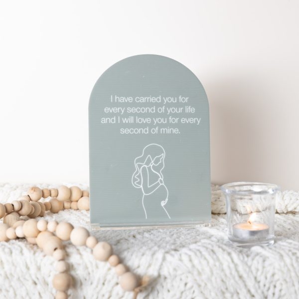 UV printed olive green acrylic memorial arch plaque with mother illustration and quote on detachable stand. Styled with a soft blanket and candle.