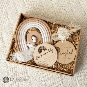 IVF rainbow baby gift box with timber plaques, macreme rainbow, teething toy and newborn keepsake items. Gift Box is styled on a soft blanket.