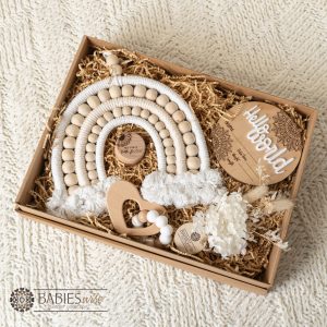 Neutral baby gift box with macrame rainbow, timber birth announcement plaque, teething ring, Tooth Fairy Box and Dried Floral arrangement. Gift Box styled on a soft blanket.