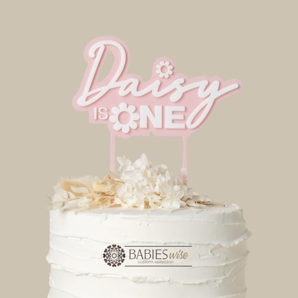 Personlised "is one" daisy- themed acrylic cake topper with child's name in layered 3D design. Styled with cake and flowers.