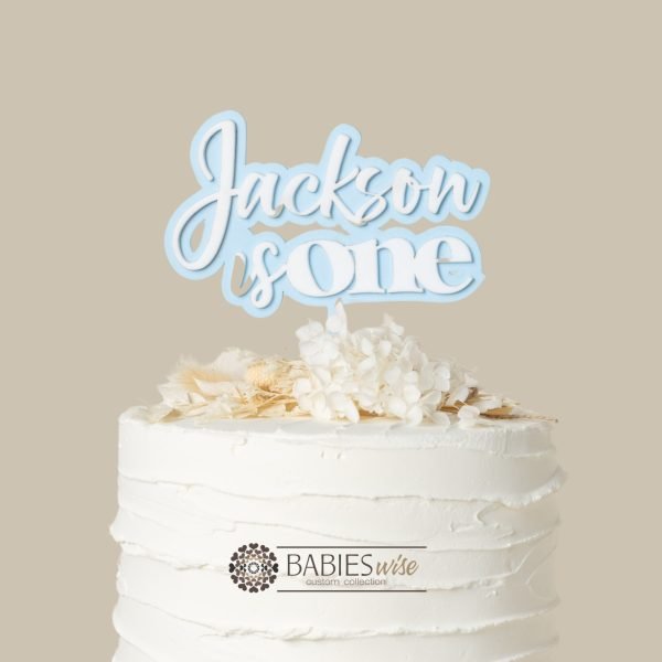 Personlised "is one" acrylic cake topper with child's name in layered 3D. Styled with cake and flowers.