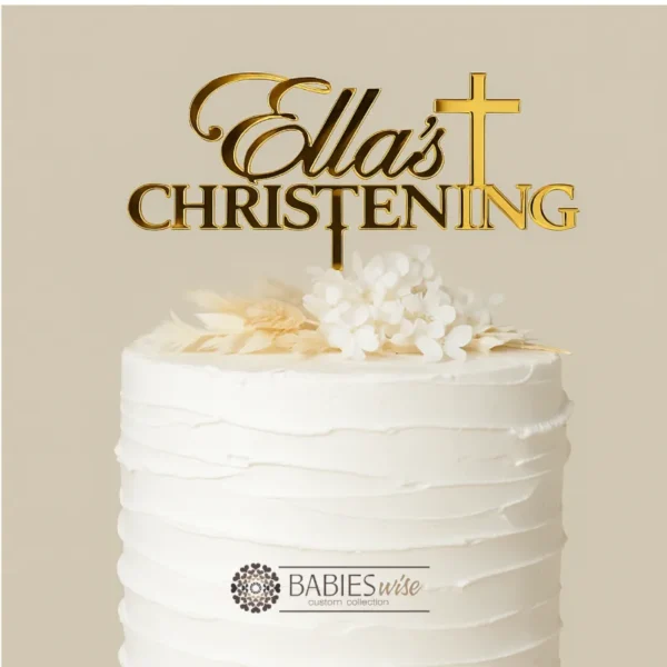 Personlised acrylic Christening cake topper featuring the name in flowing script lettering above the word Christening with a cross details. Styled on a white cake with a floral arrangement.