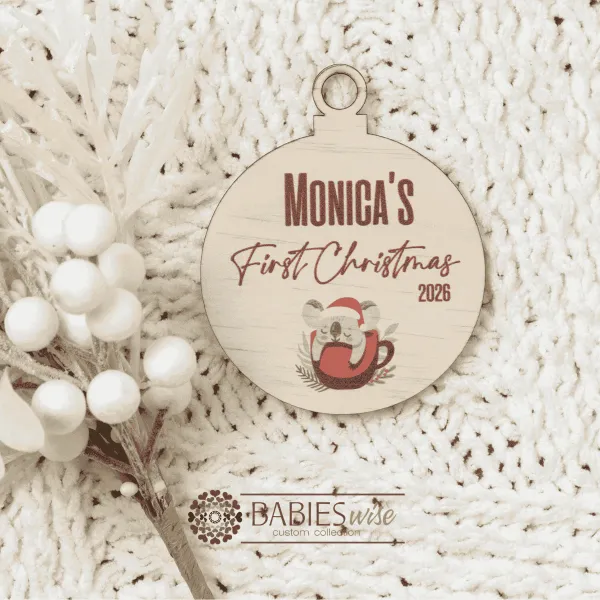 Round timber Christmas bauble UV printed with a selection of designs to choose from and personlised child's name and "First Christmas" with the year. Includes a hole to hang from the Christmas Tree. Style on a warm, soft blanket with a white Christmas wreath.
