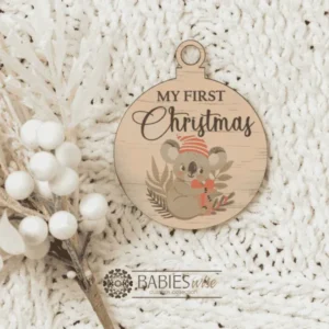 Round "My First Christmas" UV printed Bauble available in timber or UV printed acrylic in olive or Latte colours. Features festive Christmas illustrations and a hole for hanging on the Christmas tree. Styled hanging from a knob with decorative beads.
