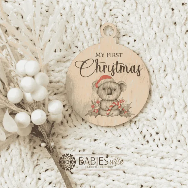 Round "My First Christmas" UV printed Bauble available in timber or UV printed acrylic in olive or Latte colours. Features festive Christmas illustrations and a hole for hanging on the Christmas tree. Styled hanging from a knob with decorative beads.