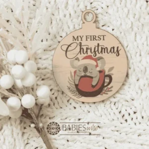 Round "My First Christmas" UV printed Bauble available in timber or UV printed acrylic in olive or Latte colours. Features festive Christmas illustrations and a hole for hanging on the Christmas tree. Styled hanging from a knob with decorative beads.