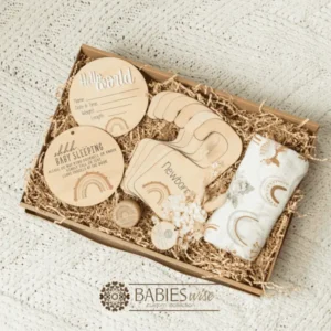 Baby girl keepsake gift box featuring a timber birth announcement plaque, matching "Shh.. Baby Sleeping" plaque, wardrobe dividers, Tooth Fairy Box and swaddle. Styling- Products placed in a Kraft Paper Gift Box with Kraft shredded paper on a soft blanket.