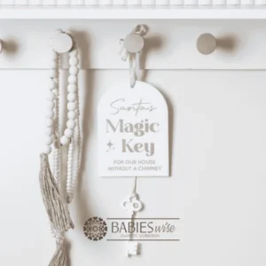 Acrylic arch Christmas hanger UV printed with "santa's Magic Key" and hanging white acrylic key. Includes a hole at the top for hanging with ribbon or string. Styled hanging from a knob with decorative beads.