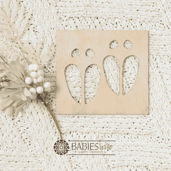 Square timber reindeer footprint stencil designed to create magical reindeer tracks on Christmas Eve using flour or powder. Styled on a soft white blanket with a white Christmas wreath.