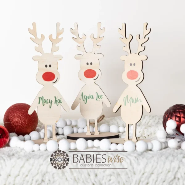 Personlised timber reindeer table stands UV printed with names. Styled on a soft white blanket with white beads and red Christmas balls.
