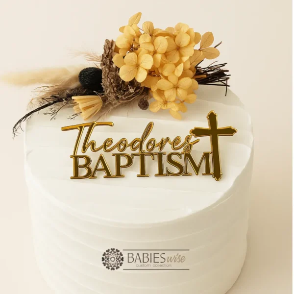 Personlised acrylic Baptism cake fropper featuring the name in script lettering above the word Baptism with a cross details. Styled on a white cake with a floral arrangement.