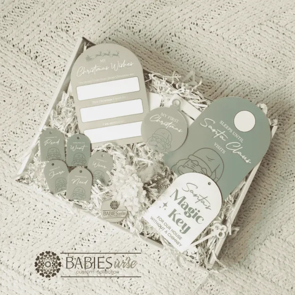 Christmas Gift Box Acrylic UV printed Olive featuring a corordinated colllection of reusable Christmas keepsakes in soft Olive and white tones, beautifully presented in a whit gift box. Styled on a soft white blanket.