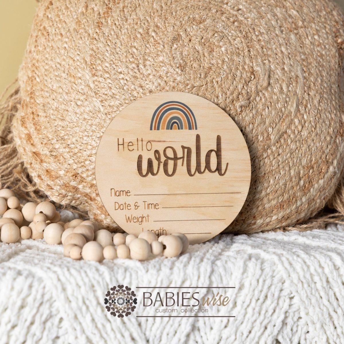 Hello world timber birth annoucement - Blue Rainbow. Styled on a soft white blanket with a woven pillow & wooden beads.