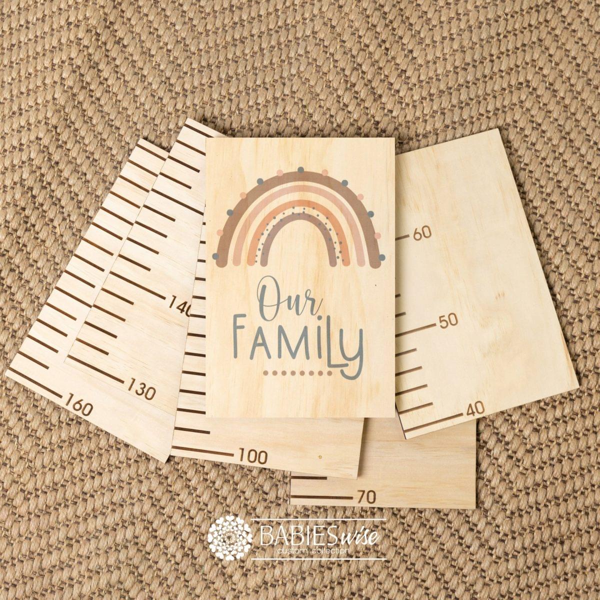 Timber growth chart with five panels and a header with a earthy rainbow with "Our Family" text. Styled with a woven mat.